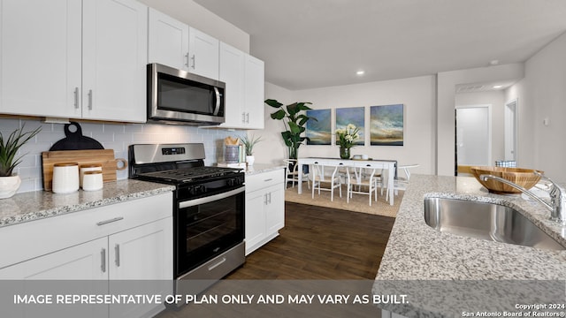 kitchen featuring white cabinetry, appliances with stainless steel finishes, dark wood-type flooring, and sink