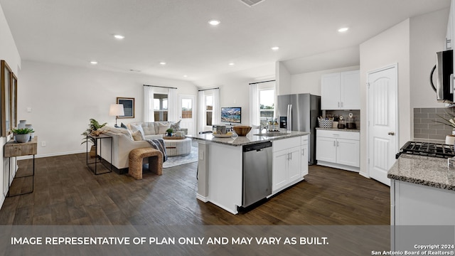 kitchen with an island with sink, white cabinets, appliances with stainless steel finishes, and light stone countertops