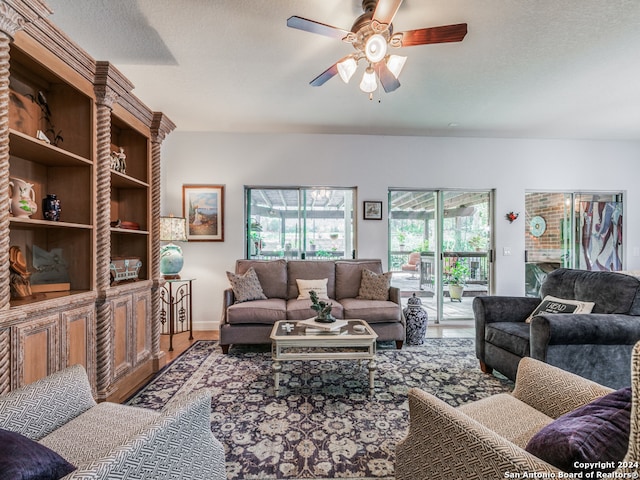 living room featuring ceiling fan, a textured ceiling, and hardwood / wood-style floors