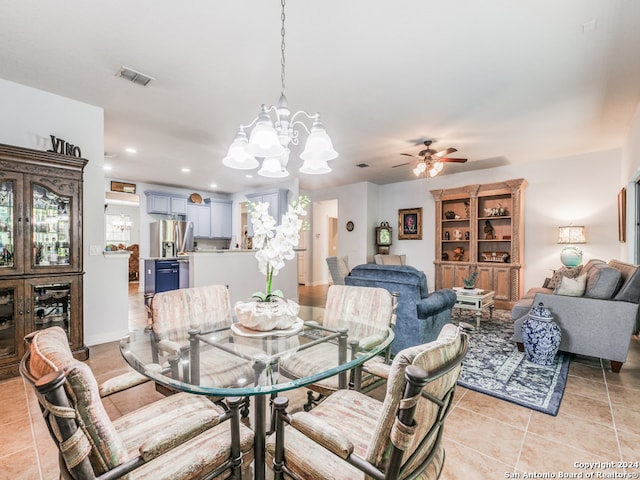 tiled dining area with ceiling fan with notable chandelier