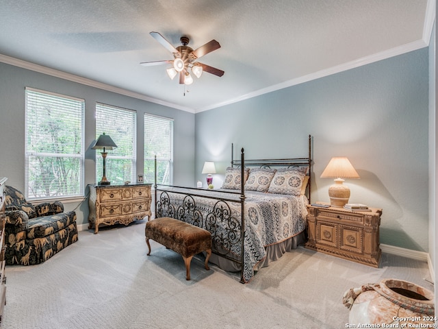 bedroom with ceiling fan, a textured ceiling, light carpet, and crown molding