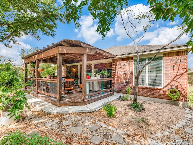 back of house with a wooden deck, a pergola, and a patio