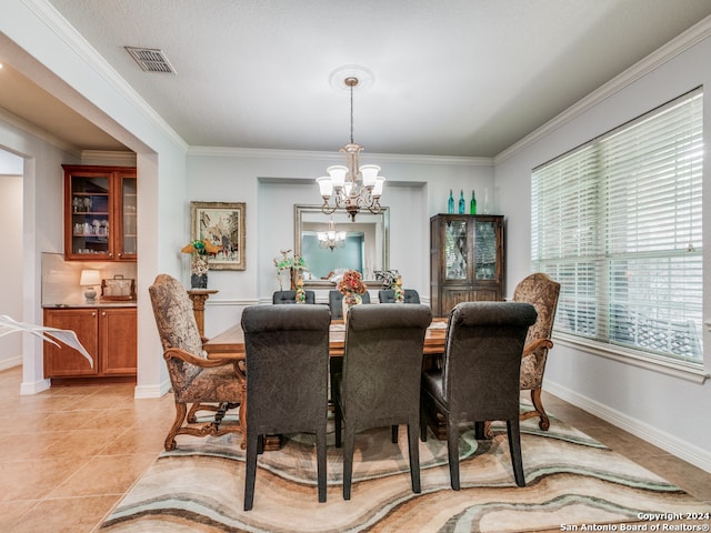 dining area with ornamental molding, a chandelier, and light tile patterned floors