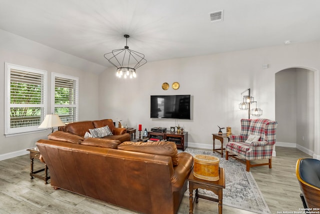 living room with an inviting chandelier and light hardwood / wood-style floors