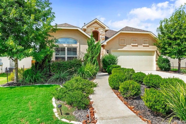 front of property featuring a front lawn, central AC unit, and a garage