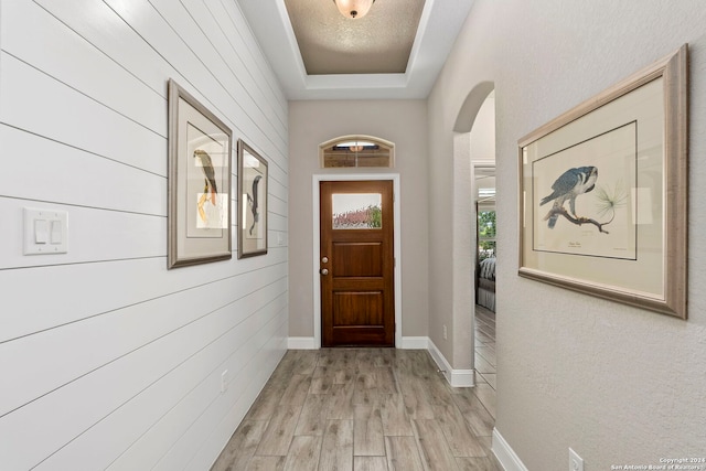 entryway featuring light hardwood / wood-style floors and wooden walls