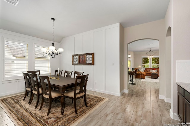 dining space featuring a notable chandelier and light wood-type flooring