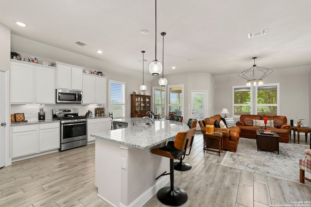 kitchen featuring a healthy amount of sunlight, stainless steel appliances, and decorative light fixtures