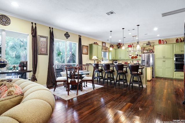 interior space featuring green cabinetry, a kitchen breakfast bar, black double oven, and stainless steel fridge with ice dispenser