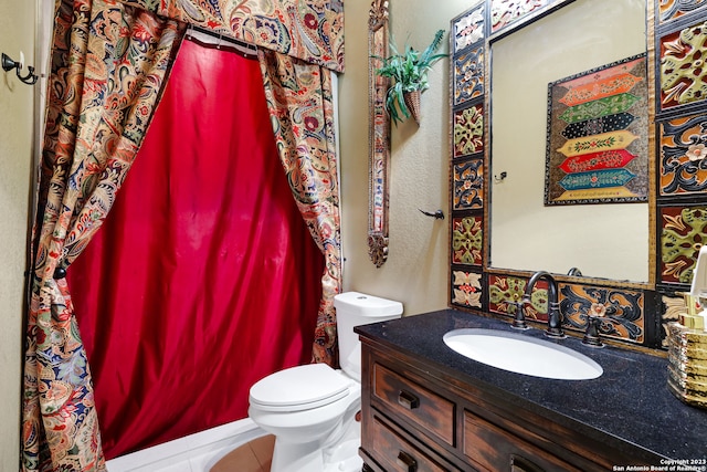 bathroom with curtained shower, tile patterned flooring, vanity, and toilet