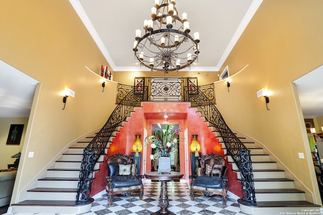 foyer with ornamental molding, a towering ceiling, and a notable chandelier