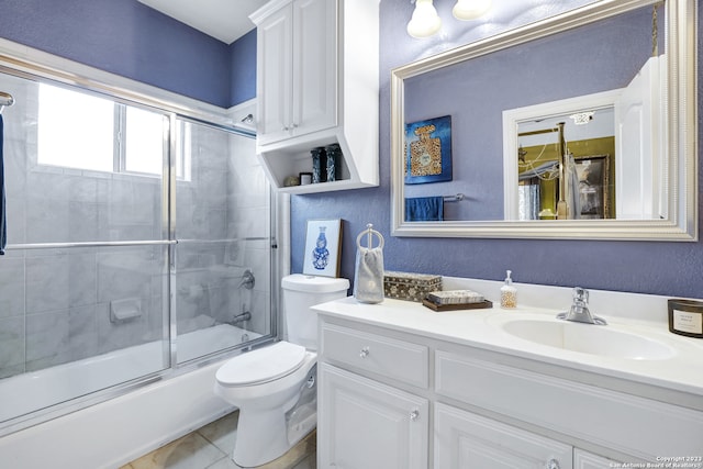 full bathroom featuring enclosed tub / shower combo, vanity, toilet, and tile patterned floors