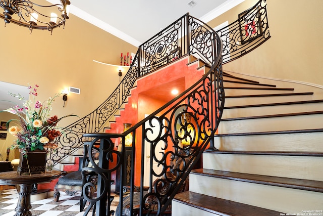 staircase featuring a notable chandelier and ornamental molding