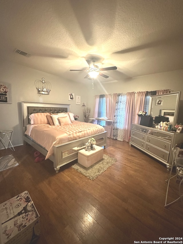 bedroom featuring dark hardwood / wood-style floors, a textured ceiling, and ceiling fan