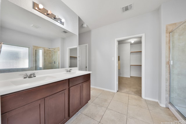 bathroom featuring vanity, a shower with shower door, and tile patterned flooring