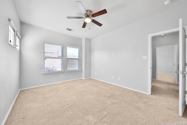 empty room with ceiling fan and light colored carpet