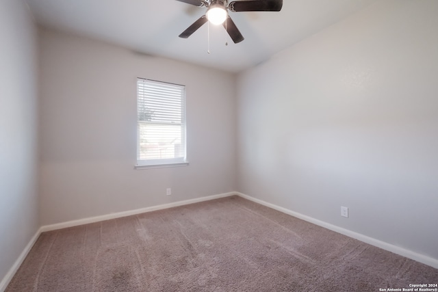 carpeted spare room featuring ceiling fan