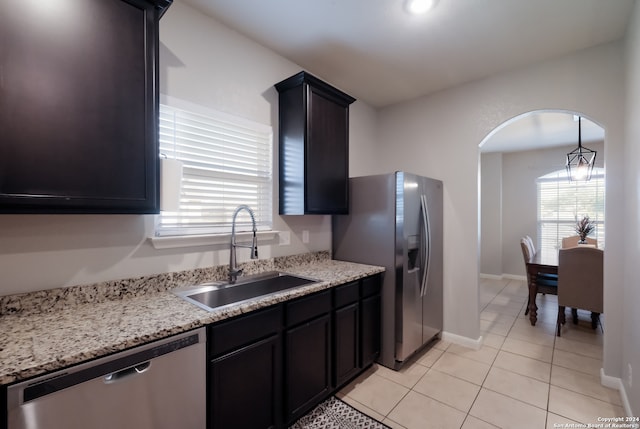 kitchen with sink, light tile patterned floors, stainless steel appliances, and light stone counters