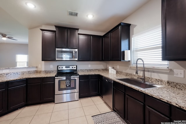 kitchen featuring light tile patterned floors, stainless steel appliances, dark brown cabinets, ceiling fan, and sink