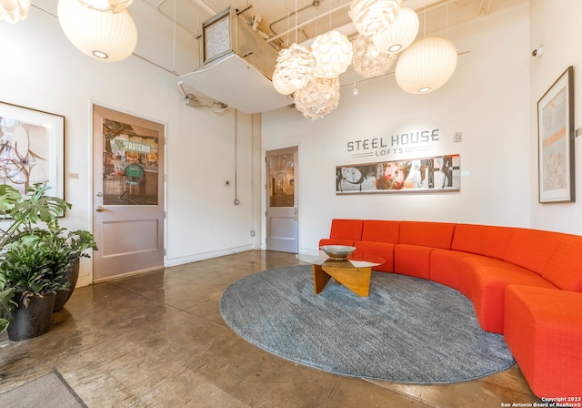 interior space featuring concrete flooring and a towering ceiling