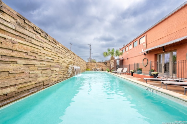 view of swimming pool with pool water feature