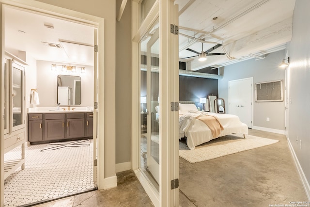 bedroom featuring connected bathroom and sink