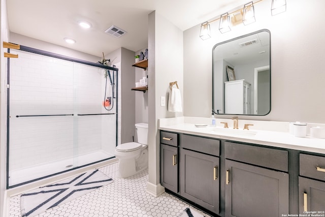 bathroom featuring tile patterned flooring, a shower with door, vanity, and toilet