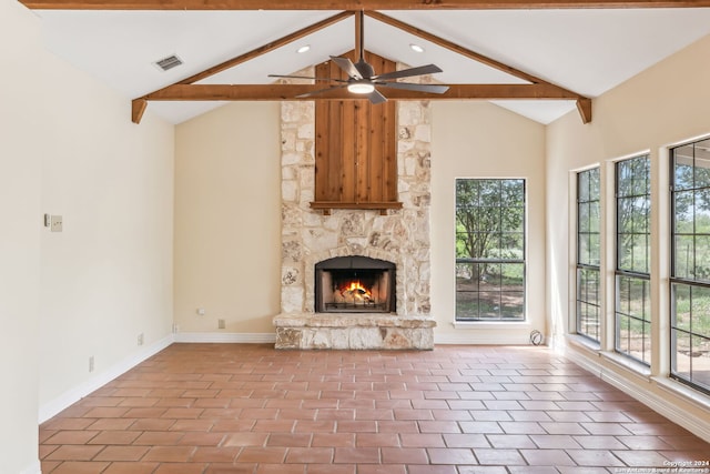 unfurnished living room with high vaulted ceiling, beam ceiling, ceiling fan, and a stone fireplace