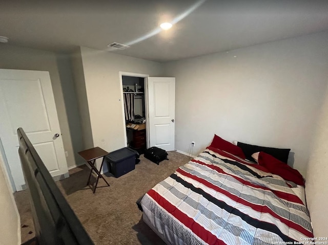 bedroom with a closet, a walk in closet, and carpet flooring