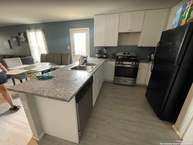 kitchen featuring stainless steel appliances, white cabinetry, light wood-type flooring, and sink