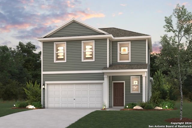 view of front of home featuring a garage and a yard