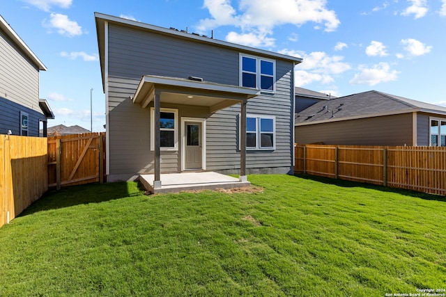 back of property featuring a yard and a patio