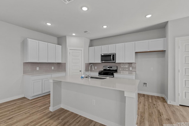 kitchen featuring white cabinetry, a kitchen island with sink, sink, and appliances with stainless steel finishes