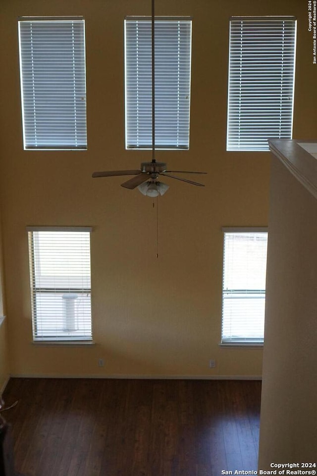 unfurnished room with dark hardwood / wood-style flooring and ceiling fan