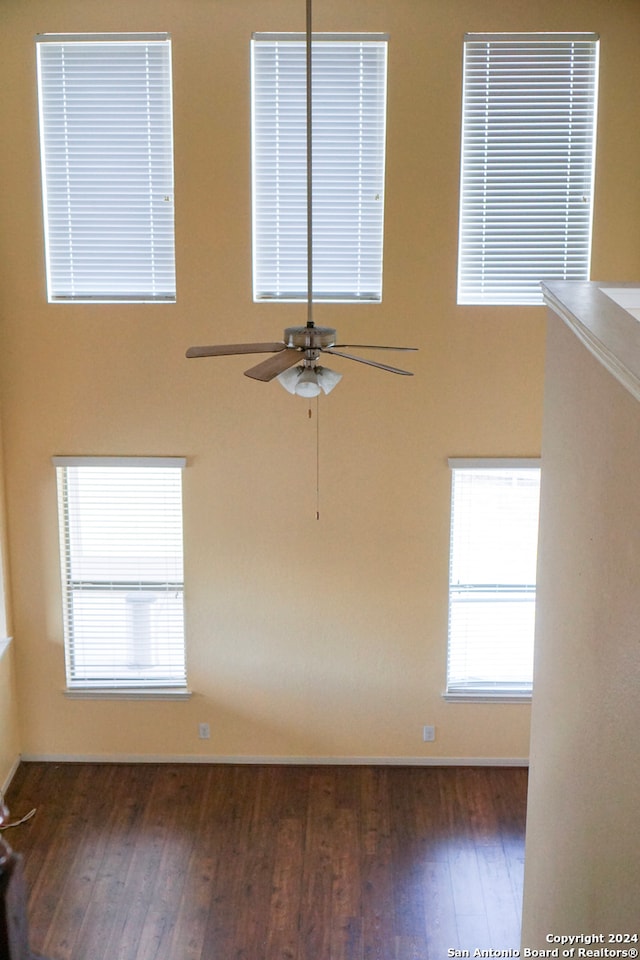 spare room with dark wood-type flooring and ceiling fan