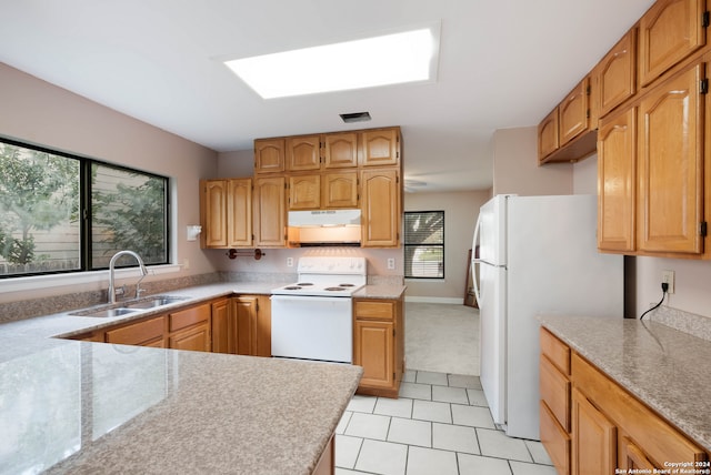 kitchen with light tile patterned floors, a skylight, sink, and white appliances