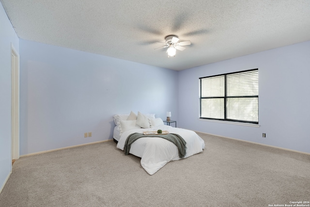 carpeted bedroom with a textured ceiling and ceiling fan