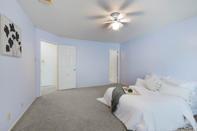 bedroom with a textured ceiling, carpet flooring, and ceiling fan