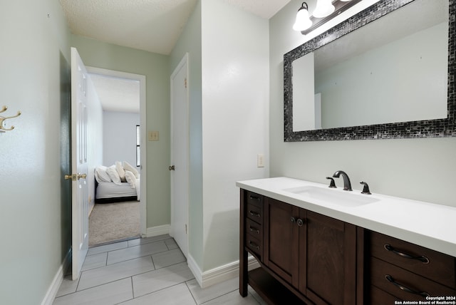 bathroom with vanity, tile patterned flooring, and a textured ceiling