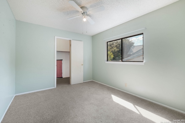 unfurnished bedroom featuring a textured ceiling, carpet, ceiling fan, and a closet