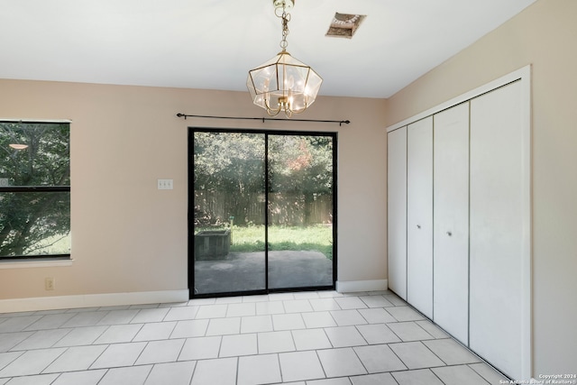 interior space with an inviting chandelier, light tile patterned floors, and a wealth of natural light