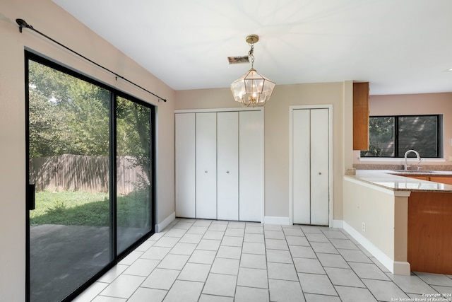 interior space featuring light tile patterned floors, a notable chandelier, and sink