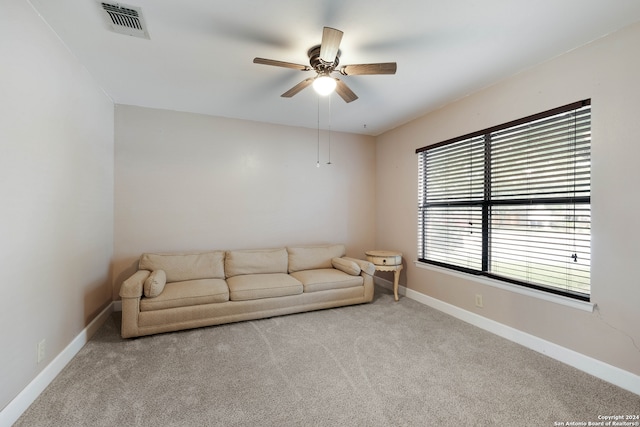 unfurnished living room featuring light carpet and ceiling fan