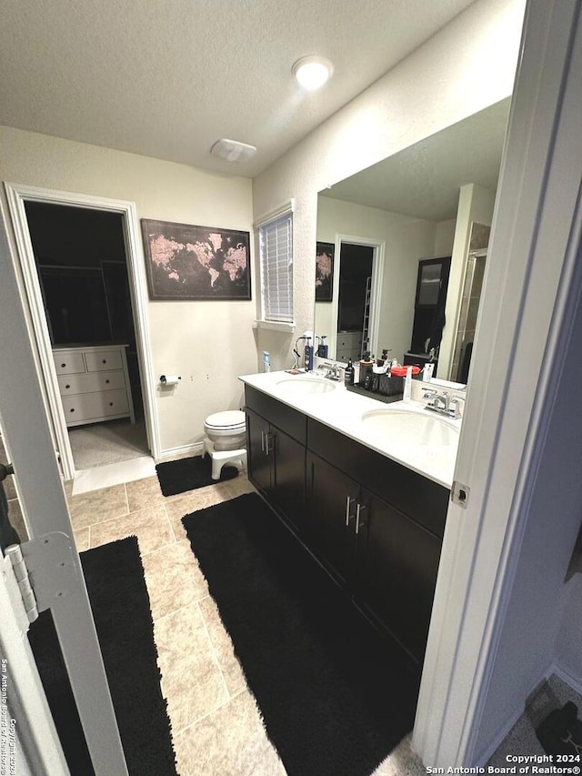 bathroom featuring vanity, a textured ceiling, and toilet