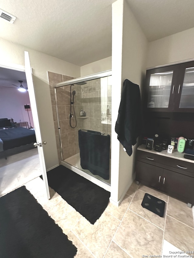 bathroom featuring an enclosed shower, ceiling fan, and tile patterned floors