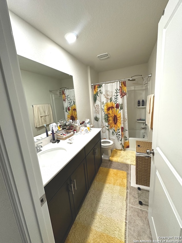 full bathroom with shower / tub combo, a textured ceiling, vanity, tile patterned floors, and toilet