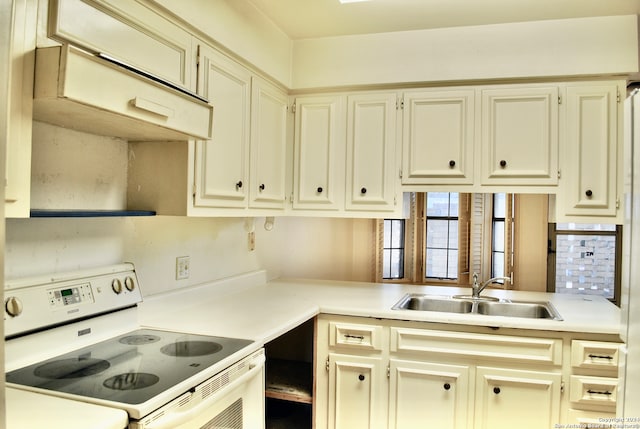 kitchen featuring electric range, sink, and cream cabinets