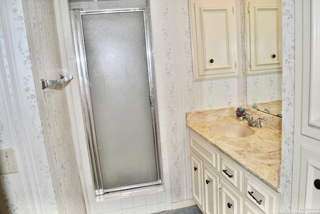 bathroom with vanity and a shower with shower door