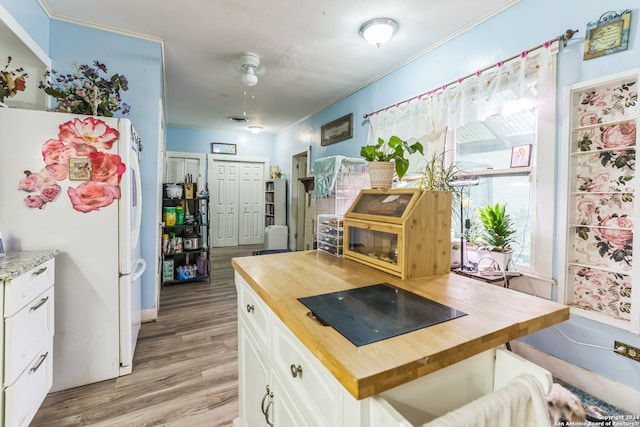 kitchen featuring wood counters, white cabinetry, white fridge, and light wood-type flooring