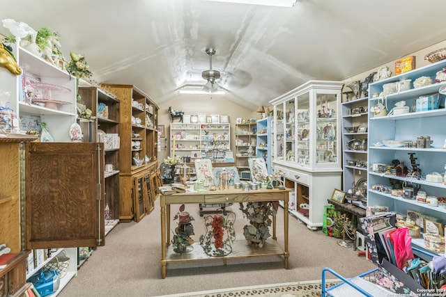 carpeted home office with ceiling fan and vaulted ceiling